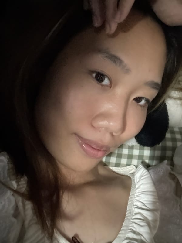 Woman poses with plush toy on bed in China