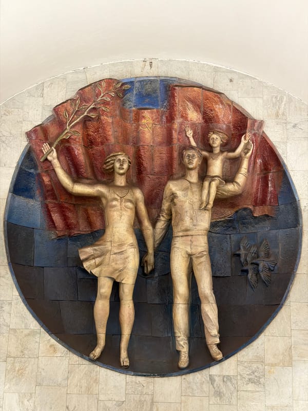 Soviet-style bas-relief sculpture of family, flag, and birds in Moscow