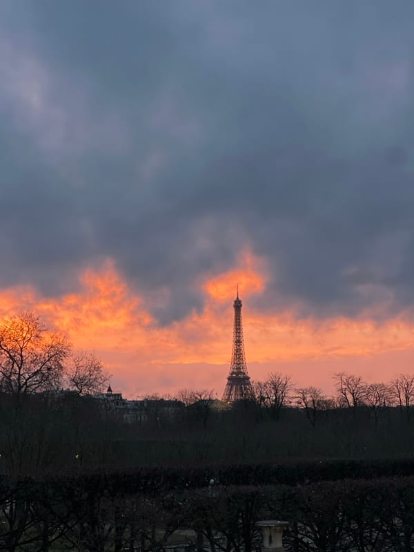 Dramatic sunset illuminates Eiffel Tower amid stormy Paris skies