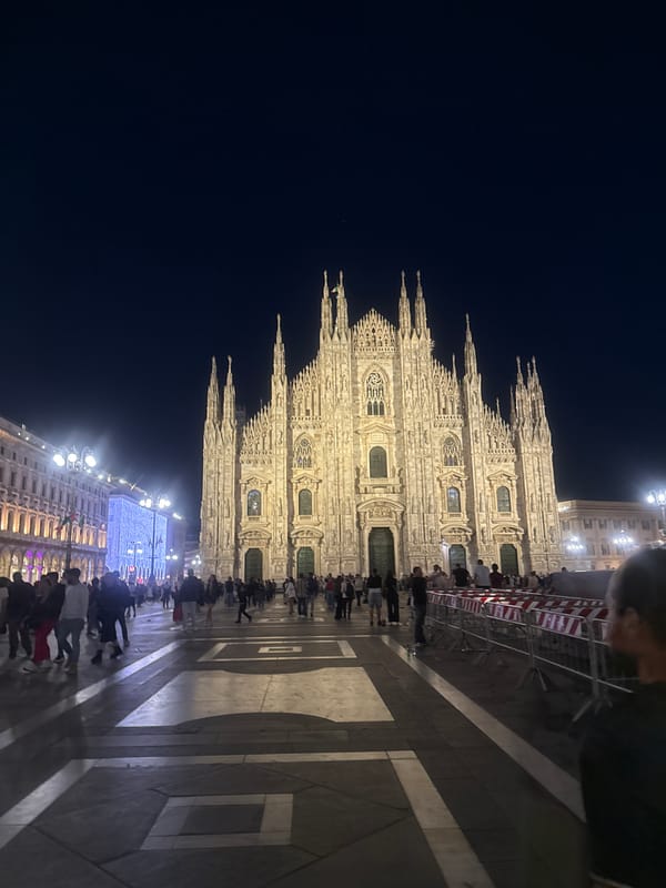 Evening crowd gathers at illuminated Milan Cathedral in Piazza del Duomo