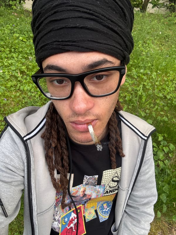 Person smoking cannabis while lying on grass in Les Ulis