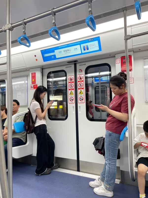 Woman uses phone on subway in Jiulongpo District