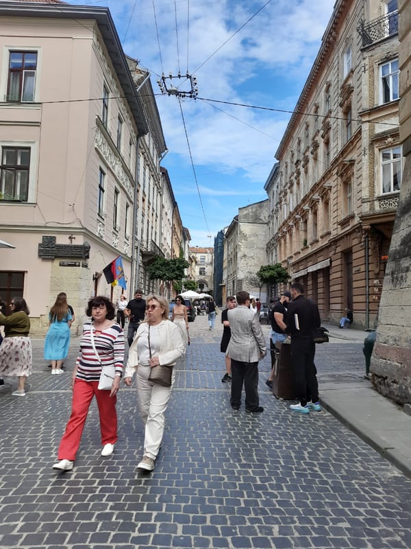 Afternoon street life near a Lviv church and café