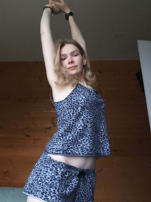 Woman in leopard-print outfit observed indoors in Russian village