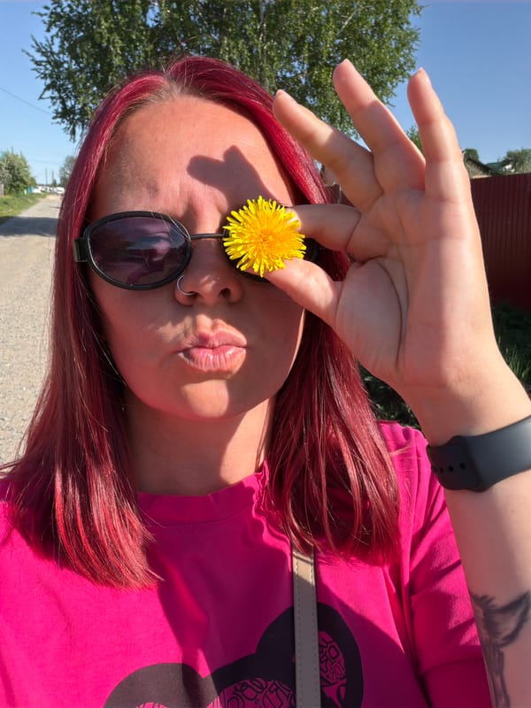 Red-haired person photographs wildflowers in Chaikovsky forest setting