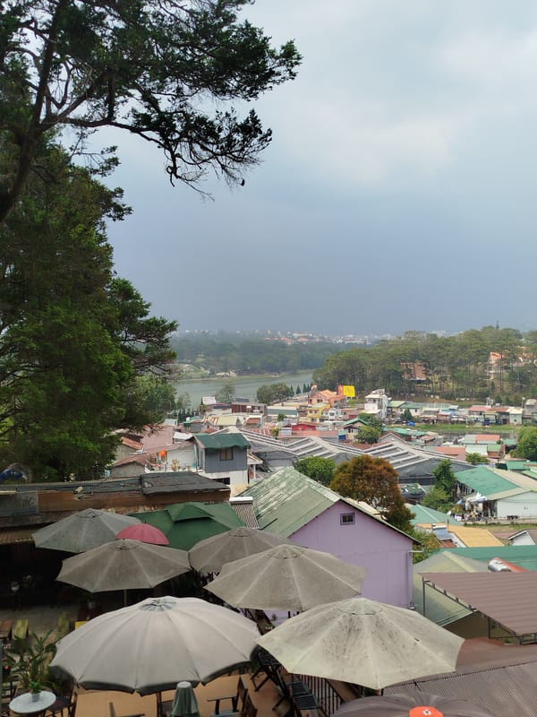 Umbrellas shield outdoor diners during overcast morning in Da Lat