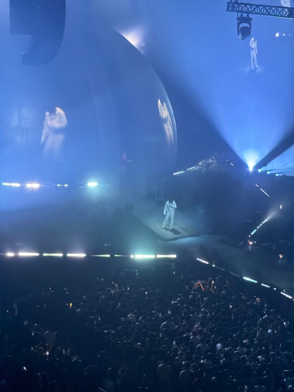 White-suited performer takes stage amid blue lights in Montreal concert