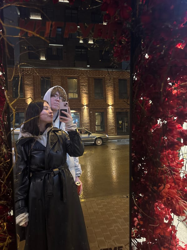 Two people photographed in reflection on wet surface in Perm