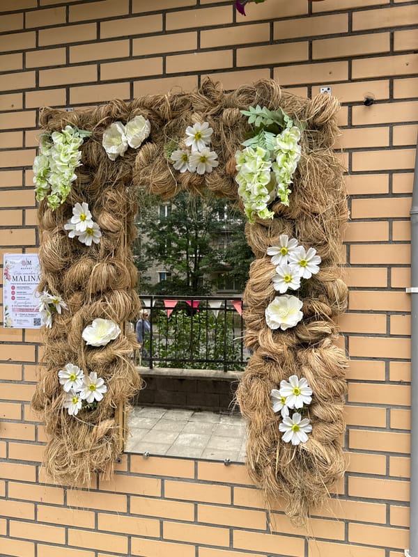 Twine archway with mirror and flowers on a Gatchina street