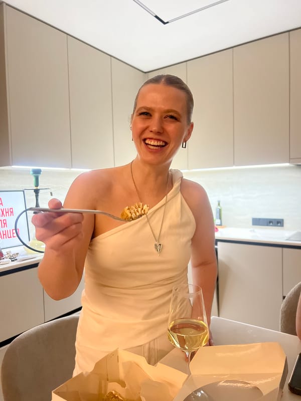 Woman enjoys wine and cake in Russian kitchen