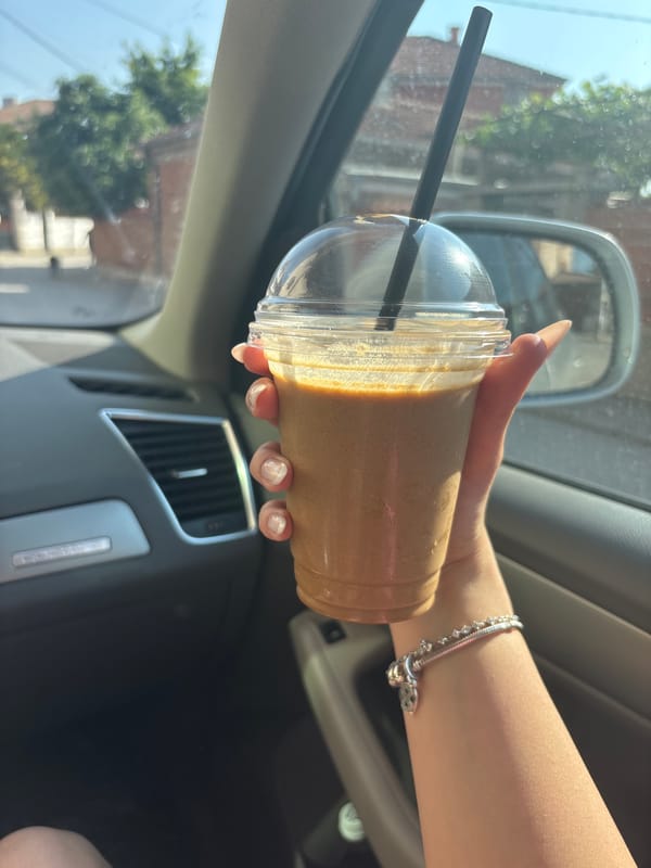 Woman enjoys iced coffee in car on sunny Rakovski afternoon