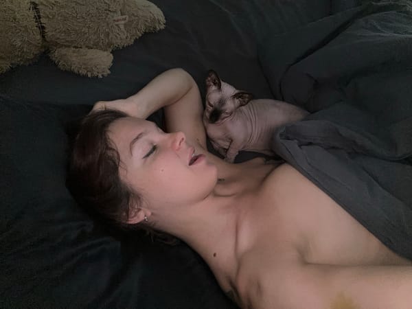 Woman rests with Sphynx cat in Vladimir bedroom
