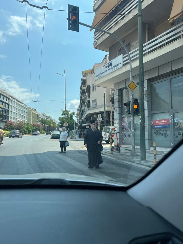 Orthodox clergy crossing a Kallithea street on a sunny morning