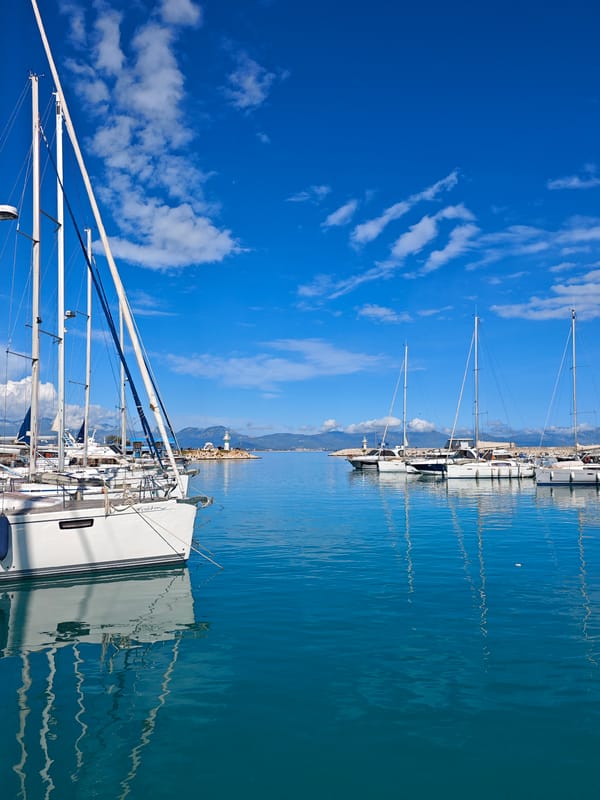 Clear skies frame Finike harbor's lighthouse and marina scene
