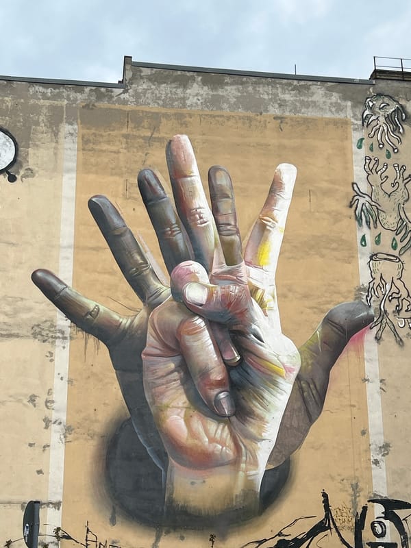Berlin street art featuring photorealistic hands mural documented