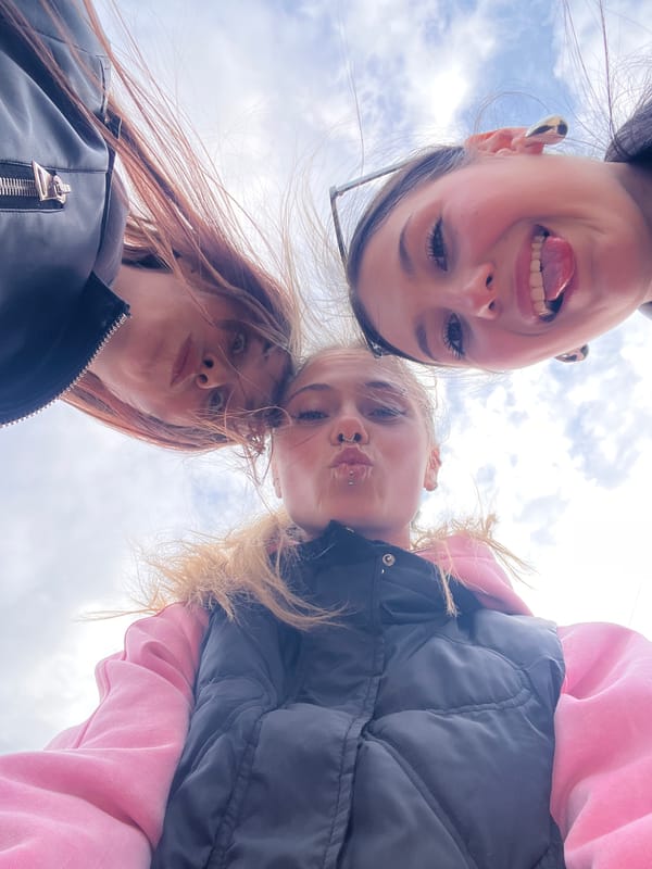 Three women photograph themselves under dramatic skies in rural Russia