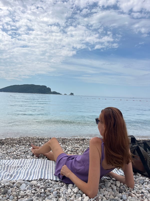 Woman in purple dress enjoys morning beach time in Budva