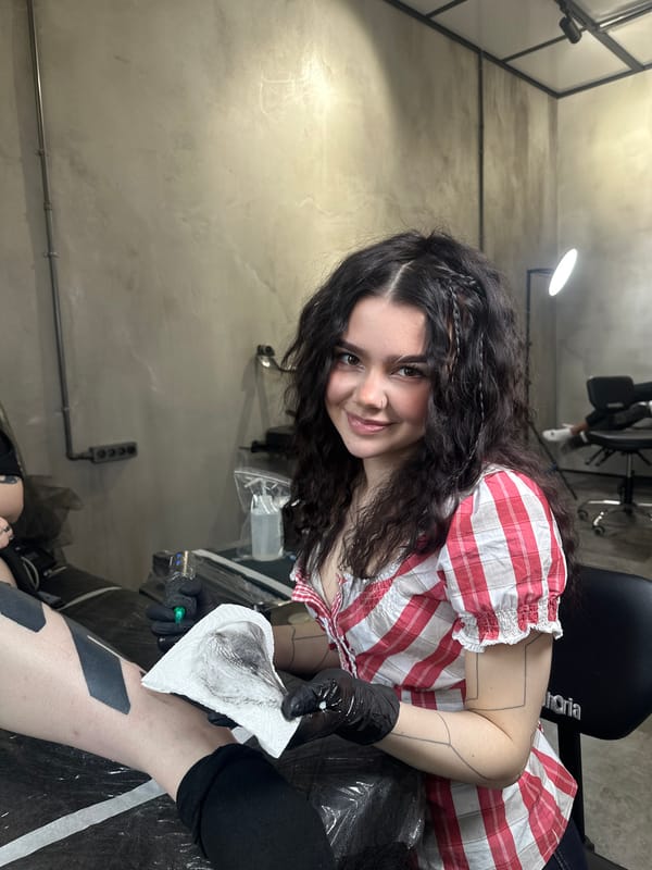 Moscow tattoo artist photographed smiling at workplace