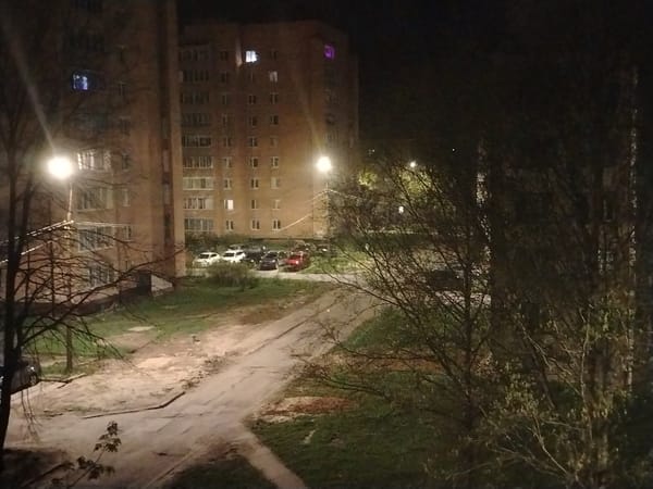 Nighttime urban scene shows two tall brick buildings