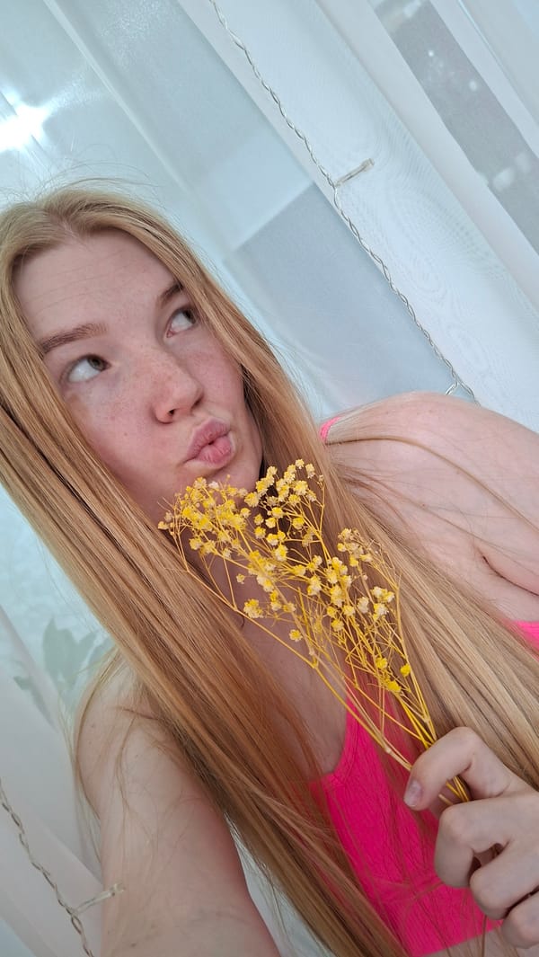 Woman poses with yellow flowers indoors in Chaikovsky, Russia