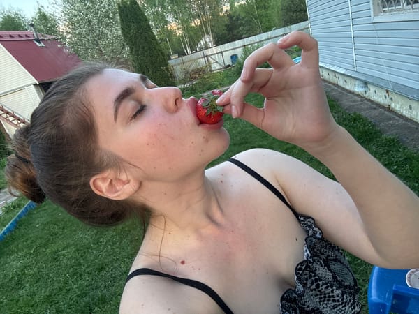 Woman enjoys strawberries outdoors in Мещёры, Russia