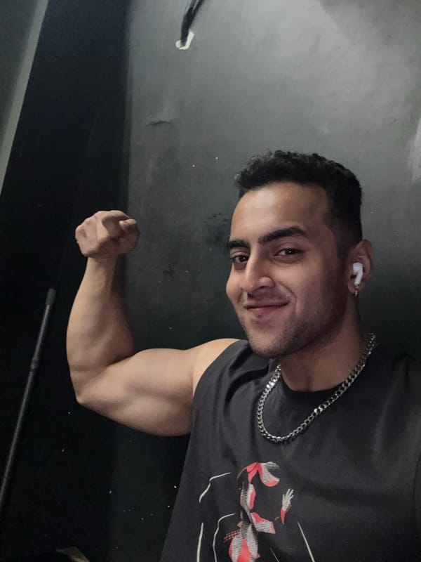 Man poses for photos flexing bicep in Kolkata room