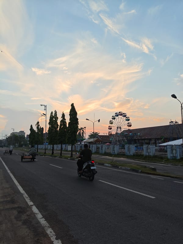 Dusk scenes across Lhokseumawe streets and an amusement park