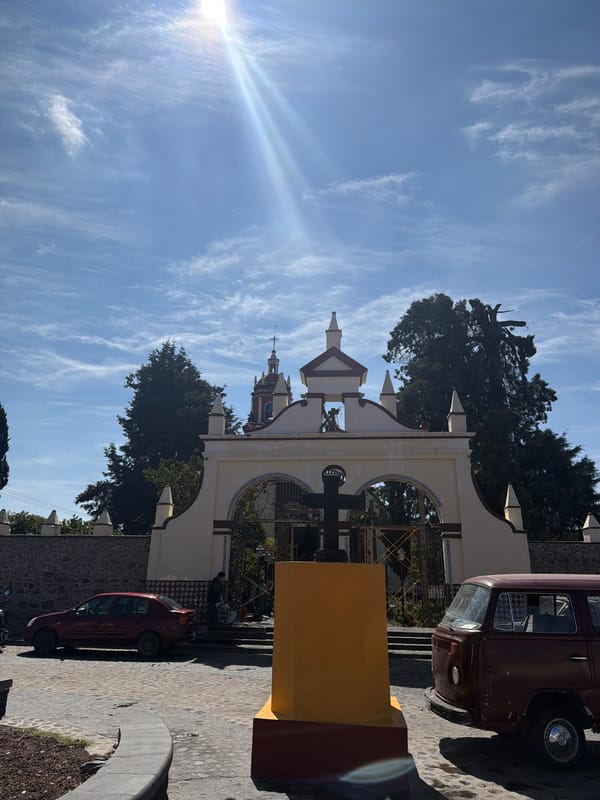 Colonial archway frames church tower in San Andrés Cholula