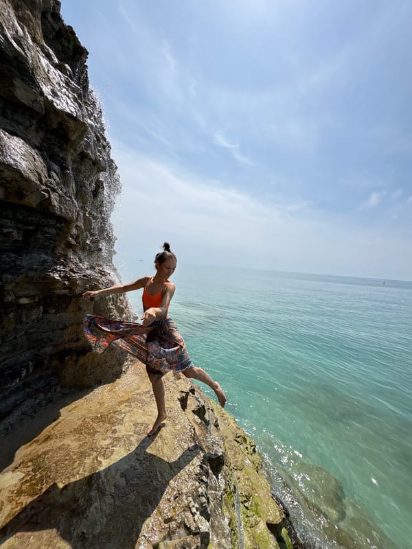 Woman poses at clifftop waterfall near Black Sea in Gelendzhik
