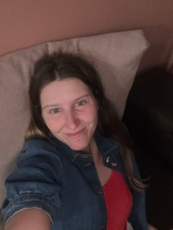 Woman and dog rest indoors during evening hours