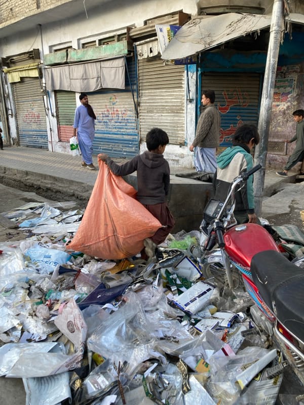 Forklift positioned near waste pile on Quetta street