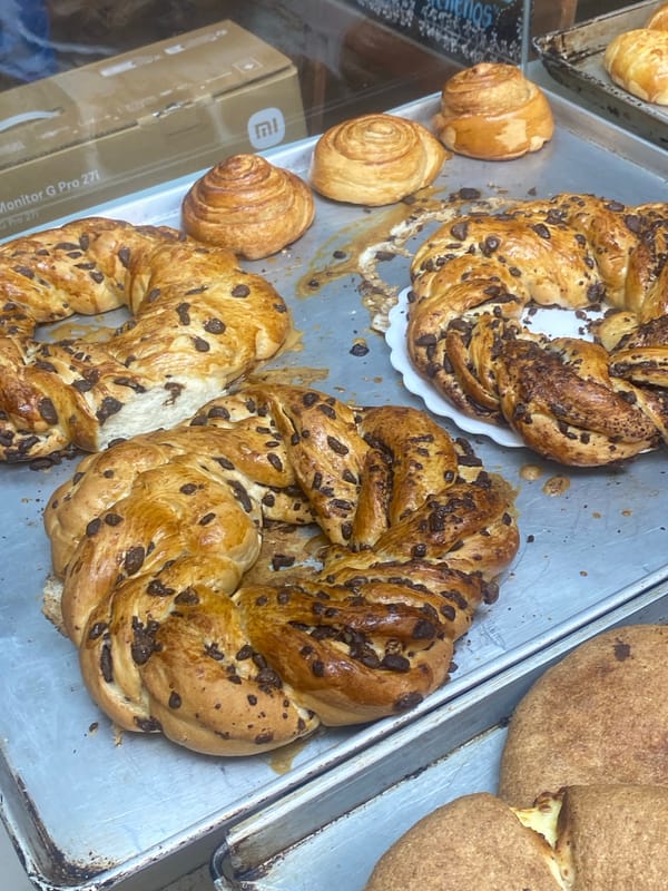 Bakery worker arranges fresh pastries in La Paz display