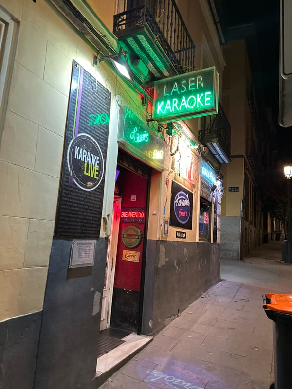 Late-night karaoke patron interacts with mannequin in Madrid bar