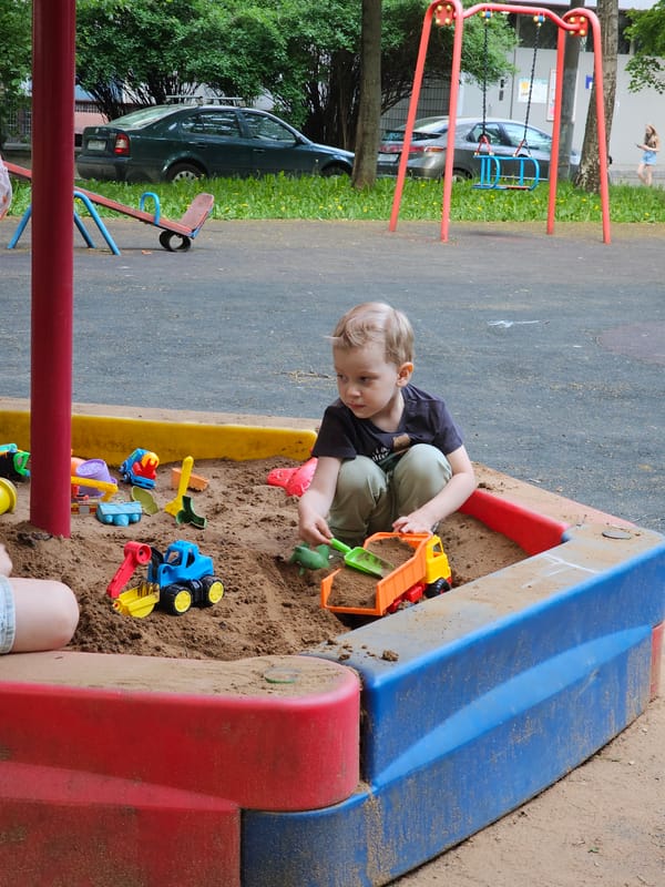 Child plays with toys in colorful sandbox at Khimki playground