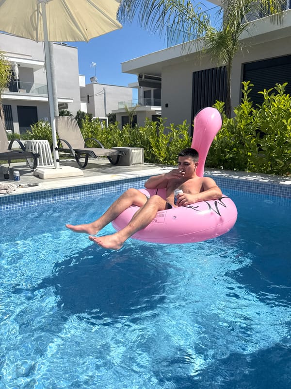 Man enjoys pool time on flamingo float at Greek beach
