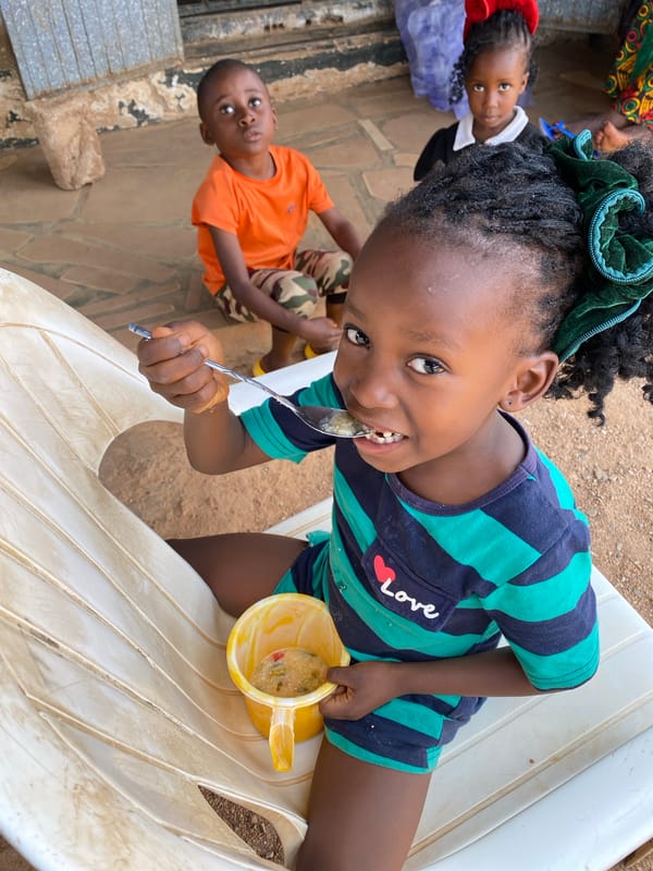 Children share mealtime on porch in Kuru Karama Nigeria
