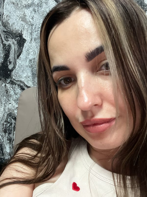 Woman takes multiple selfies during morning indoor photo session