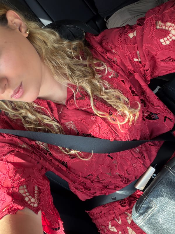 Person in red dress photographed in car seat in Miami