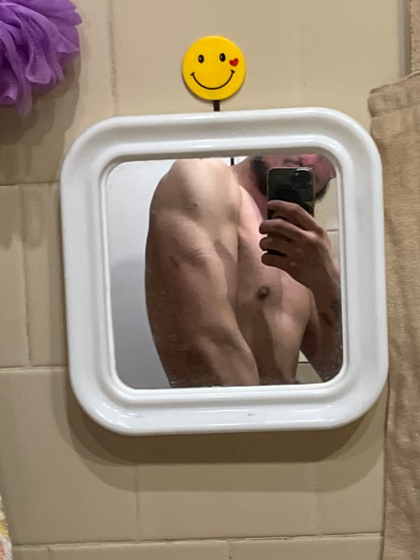 Person takes bathroom mirror selfie in white-framed mirror