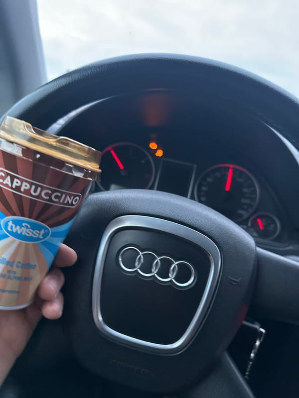 Driver holds cappuccino in Audi interior, Bulgaria