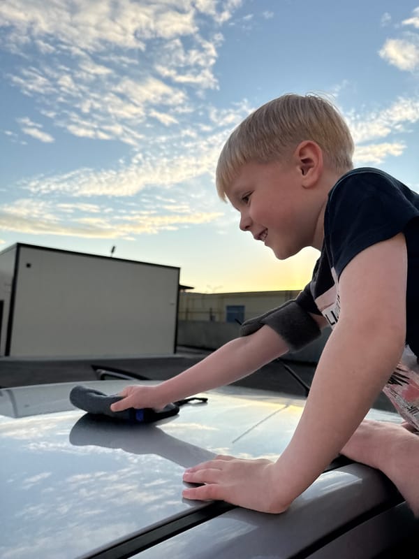 Boy washes car in Chaikovsky, Russia