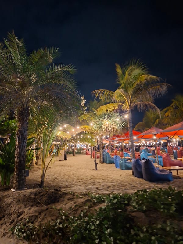 Kuta Beach bars glow at night under string lights