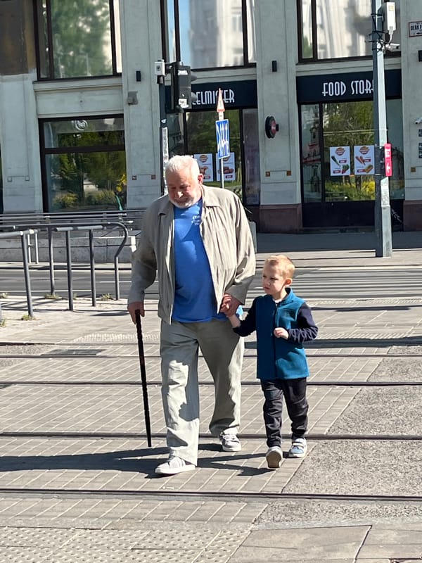 Elderly man, young boy share moment outside Budapest food store