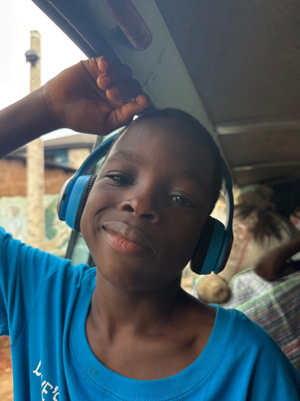 Person in blue headphones holds grab bar inside vehicle