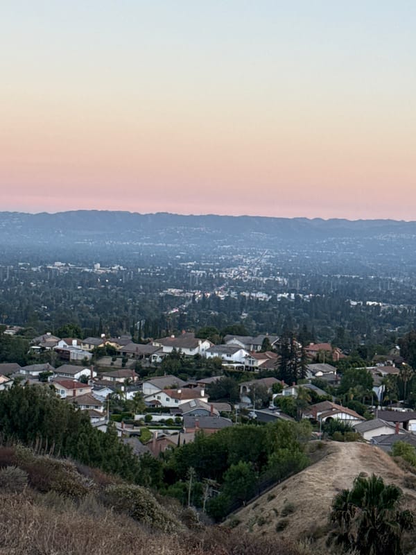 LA hillside neighborhood glows under a fading dusk sky