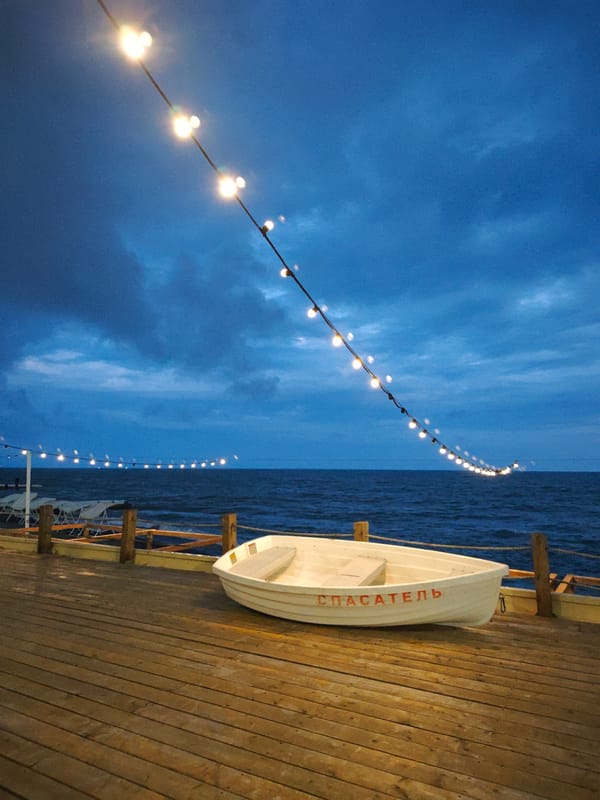 Tourist documents evening stroll along Sochi's illuminated waterfront pier