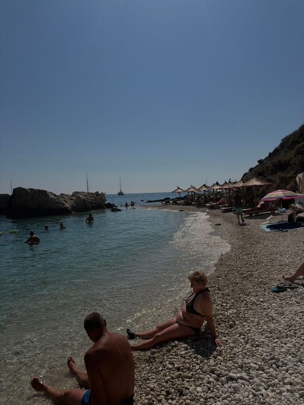 Busy Mediterranean pebble beach on a bright summer morning