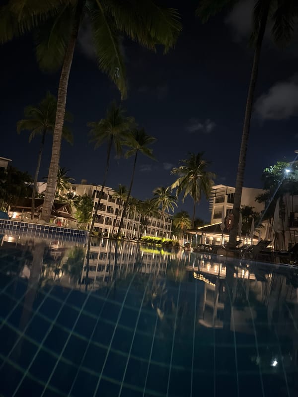 Nighttime resort pool and tuk-tuk scene in Choeng Thale