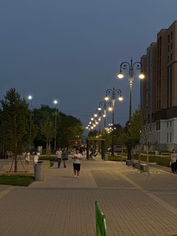 Kokshetau at dusk: lit promenade and hillside city sign