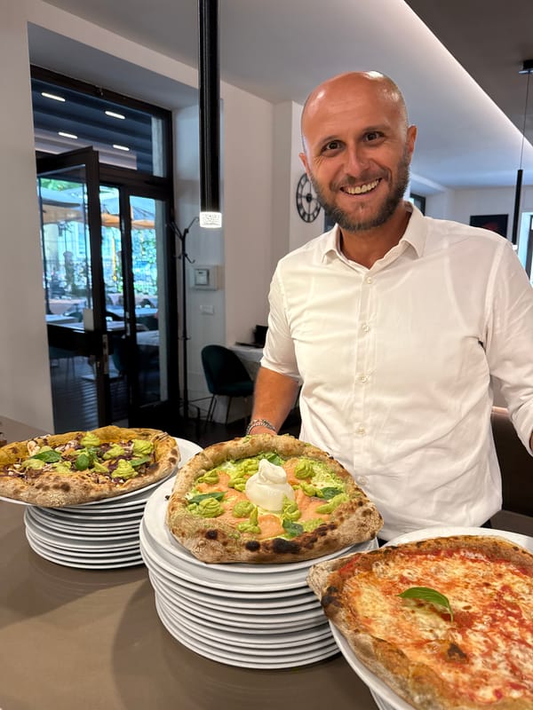 Fresh Neapolitan pizzas coming out of a dome oven in Trento